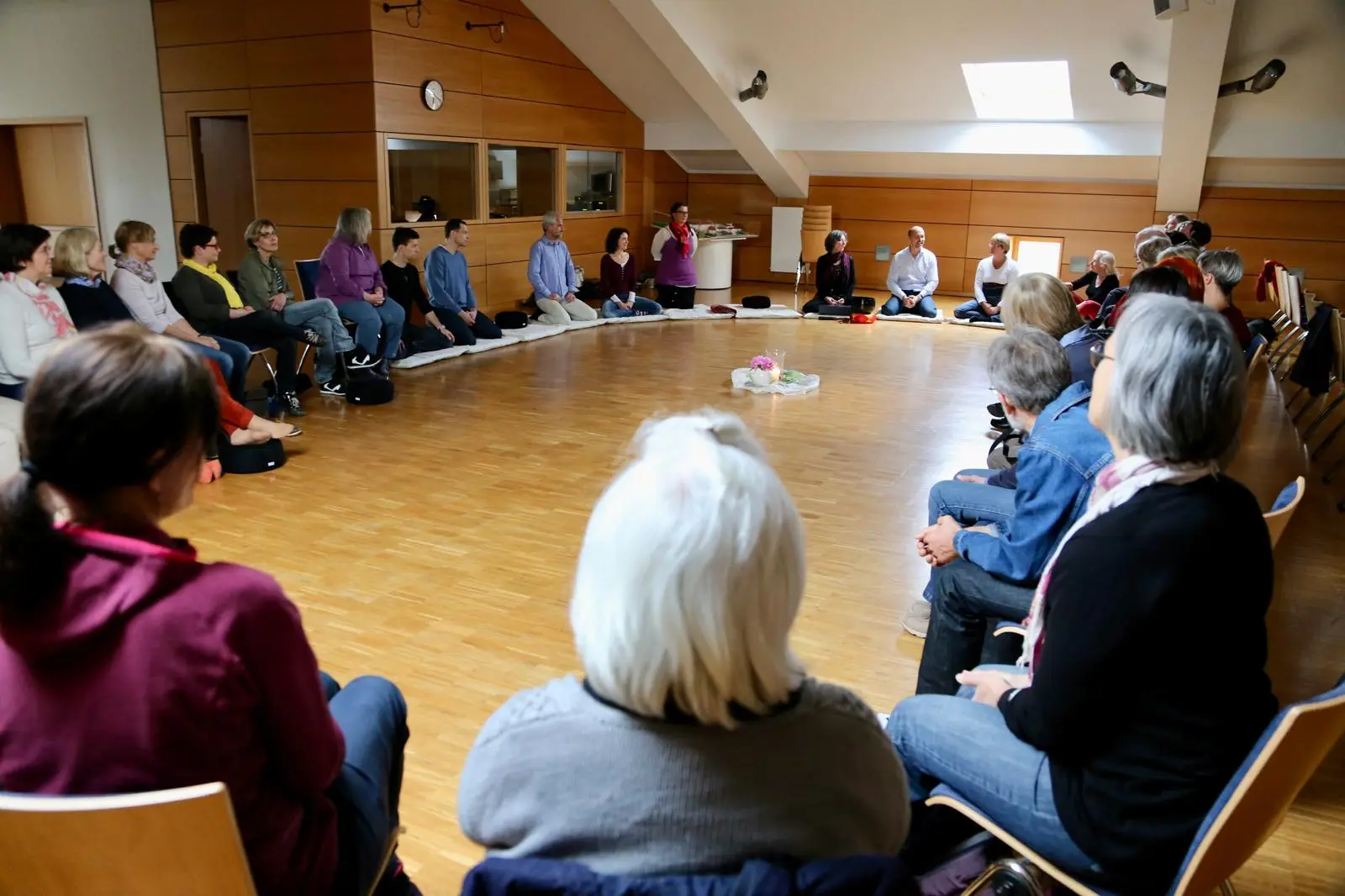 Meditationsgruppe bei der Übung der Stille in einem großen Saal in der Ortenau
